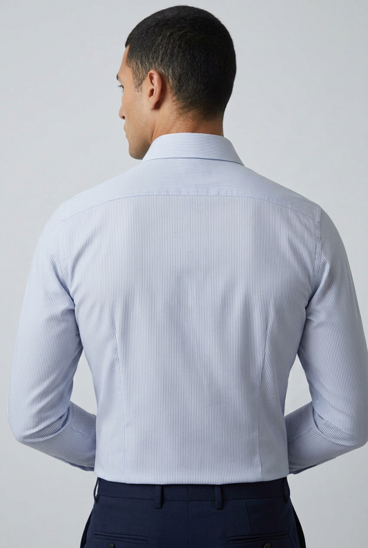 a camicia da uomo Barba Napoli C101 abbina il motivo bengal stripe, a righe bengala celesti e bianche, a una vestibilità classica. Realizzata in 100% cotone, cucita a mano e Made in Italy, presenta collo francese, maniche lunghe e polsini con bottoni. Indossata retro.