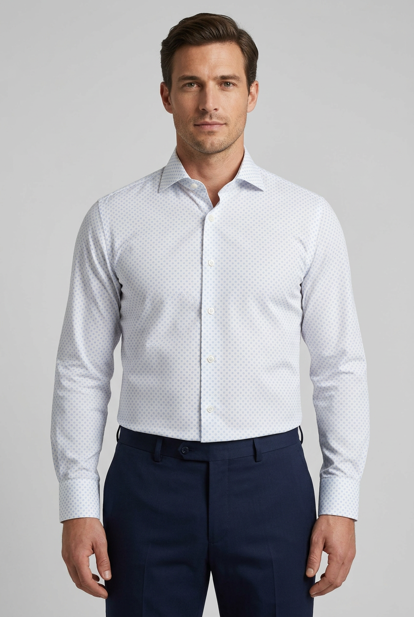 Camicia da uomo Bagutta BC342L arricchisce la base bianca con una microfantasia di cerchietti celesti, un dettaglio discreto per chi desidera un'alternativa alla tinta unita. Indossata da un modello fronte