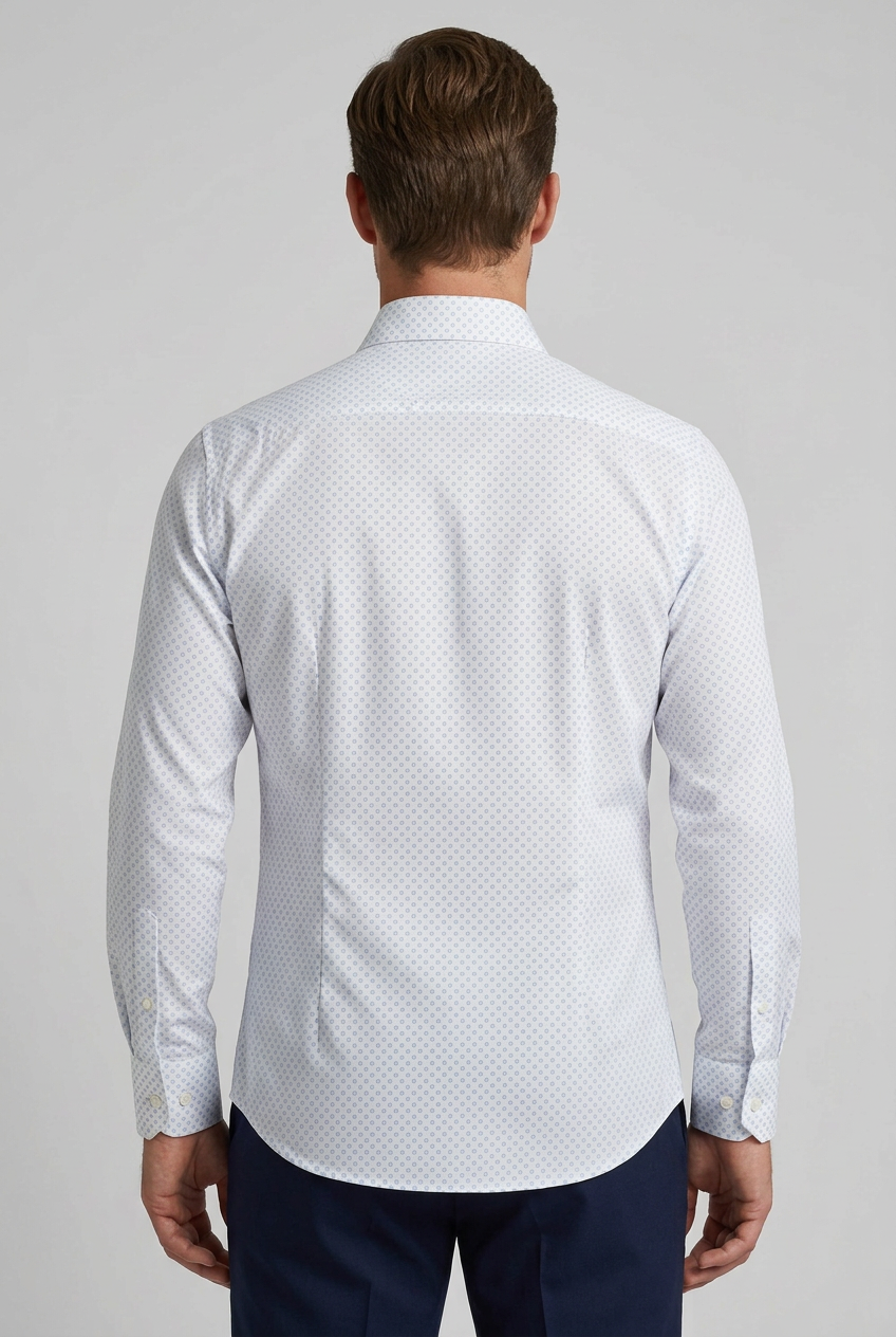 Camicia da uomo Bagutta BC342L arricchisce la base bianca con una microfantasia di cerchietti celesti, un dettaglio discreto per chi desidera un'alternativa alla tinta unita. Indossata da un modello retro