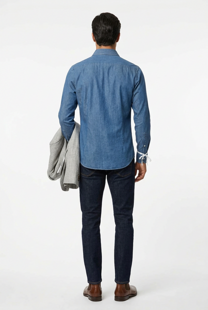 La camicia da uomo Bagutta BERLINOBJ porta il denim in un guardaroba casual curato. Realizzata in 100% cotone con vestibilità slim, abbina il collo francese all'abbottonatura con cannoncino. Le cuciture chiare a contrasto aggiungono un dettaglio distintivo alla tinta unita. indossa modello retro.