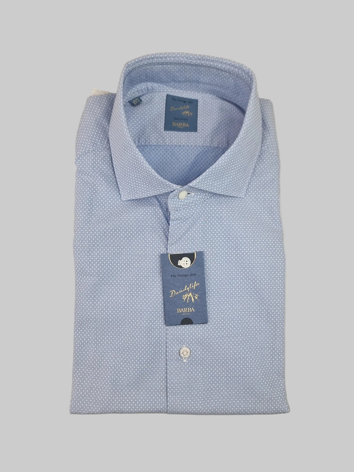 La camicia uomo Barba celeste piqué vintage abbina la luminosità del celeste a una micro fantasia discreta. Vista piegata
