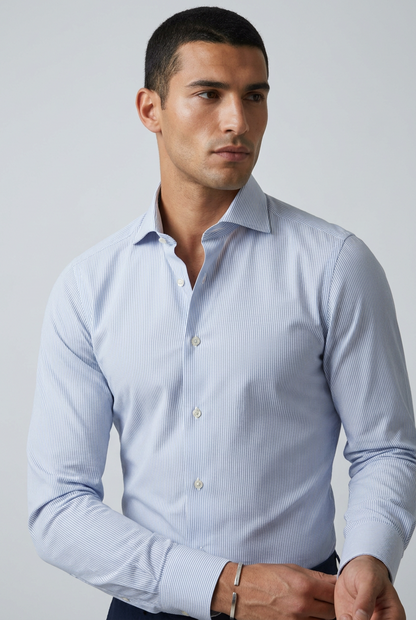 a camicia da uomo Barba Napoli C101 abbina il motivo bengal stripe, a righe bengala celesti e bianche, a una vestibilità classica. Realizzata in 100% cotone, cucita a mano e Made in Italy, presenta collo francese, maniche lunghe e polsini con bottoni. indossata fronte