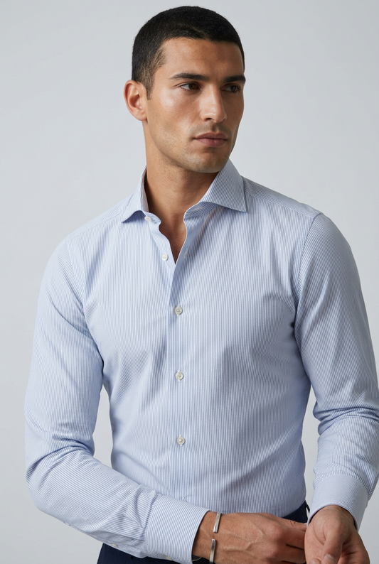 a camicia da uomo Barba Napoli C101 abbina il motivo bengal stripe, a righe bengala celesti e bianche, a una vestibilità classica. Realizzata in 100% cotone, cucita a mano e Made in Italy, presenta collo francese, maniche lunghe e polsini con bottoni. indossata fronte