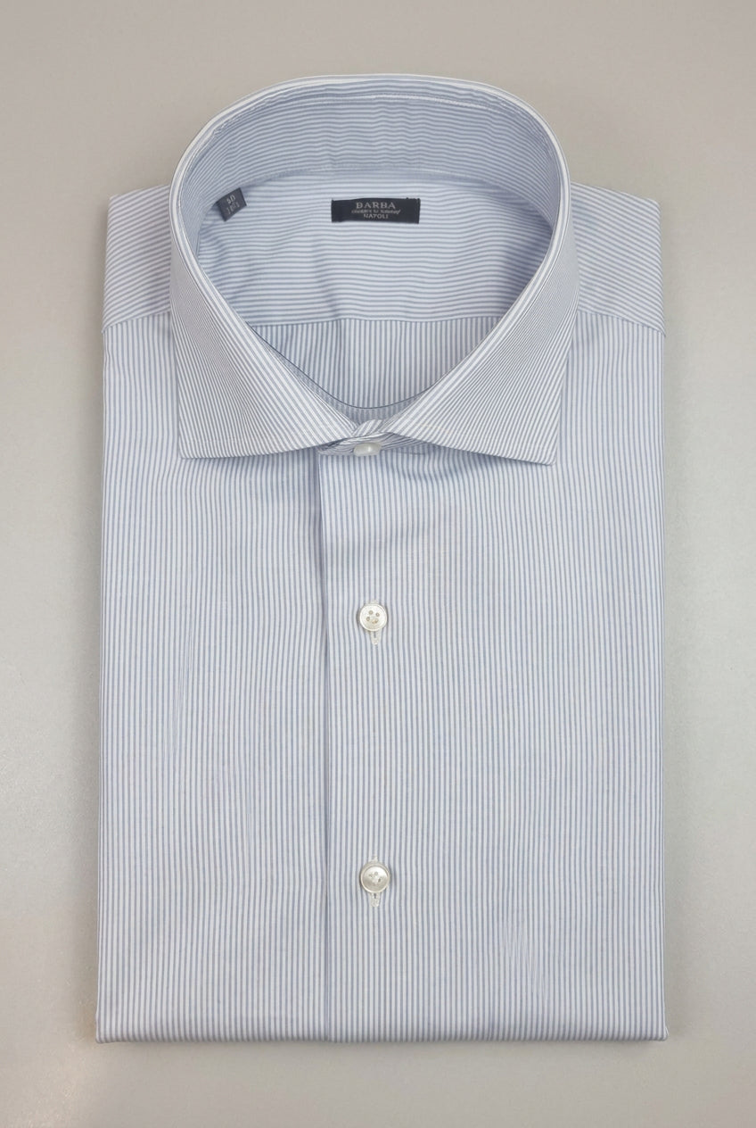 a camicia da uomo Barba Napoli C101 abbina il motivo bengal stripe, a righe bengala celesti e bianche, a una vestibilità classica. Realizzata in 100% cotone, cucita a mano e Made in Italy, presenta collo francese, maniche lunghe e polsini con bottoni. Piegata.