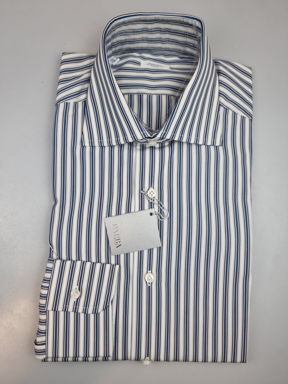 La camicia da uomo Barba Napoli C097 unisce il motivo a righe ai toni del blu e del grigio, per un look curato da abbinare a capi a tinta unita. Realizzata in 100% cotone, presenta collo francese, maniche lunghe e polsini con bottoni. Piegata.