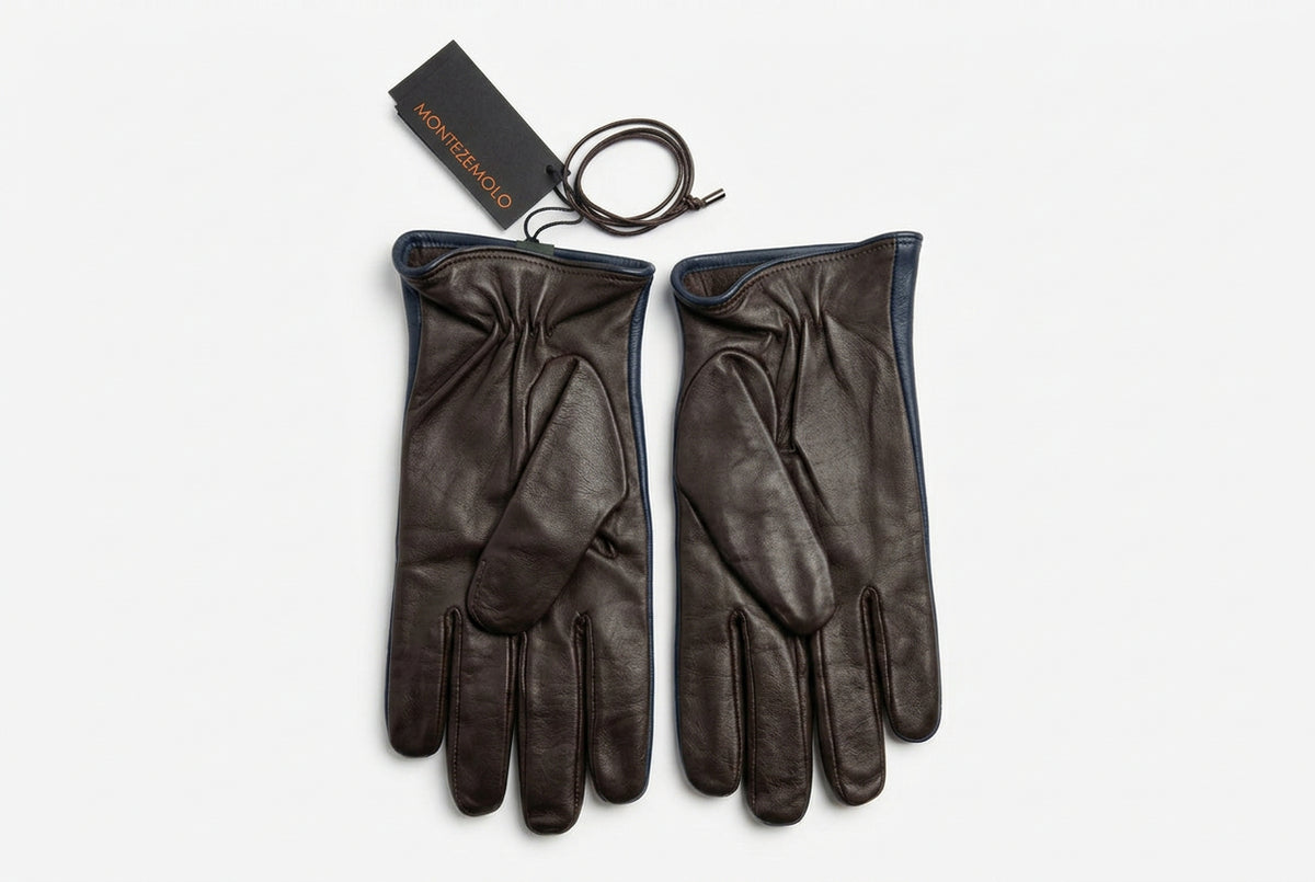 I guanti da uomo Montezemolo in vera pelle e lana aggiungono carattere ai tuoi look nelle giornate fredde. L’abbinamento testa di moro e blu offre un’eleganza discreta, facile da accostare a un cappotto sartoriale o a una giacca casual.