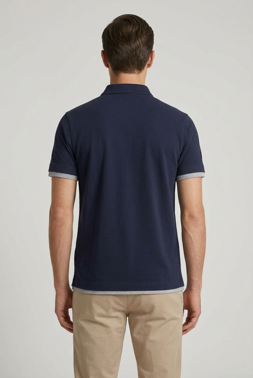 Polo Brunello Cucinelli blu notte con dettagli grigi a contrasto.
Un blu profondo, una linea essenziale e dettagli che fanno la differenza: la polo da uomo Brunello Cucinelli MTS53966 interpreta il guardaroba casual con un'eleganza discreta. Indossata retro.